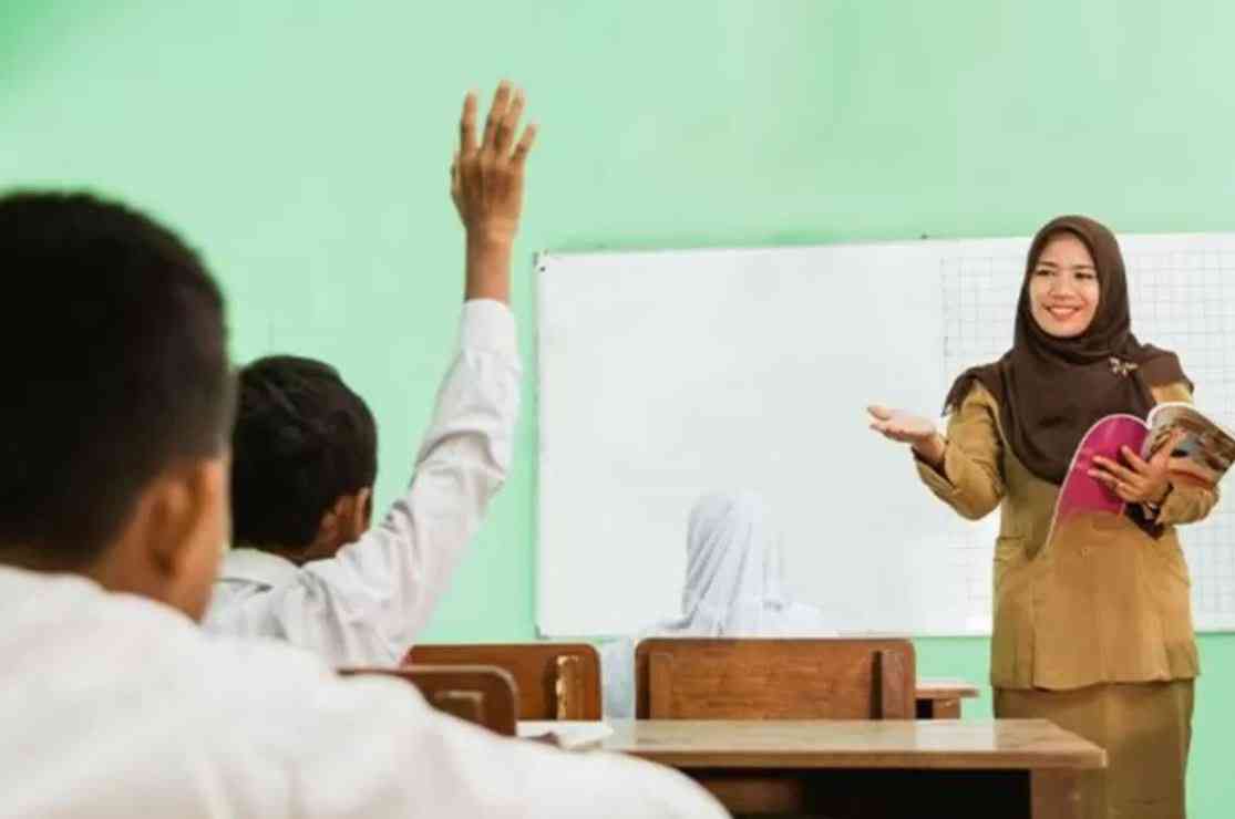 Guru mengajar di kelas.